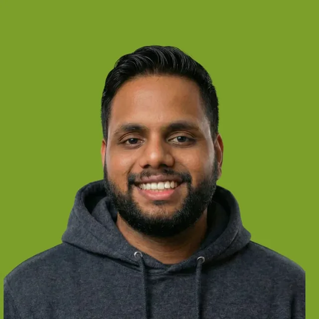 Jhonty Barreto smiling, in a grey hoodie against a green background
